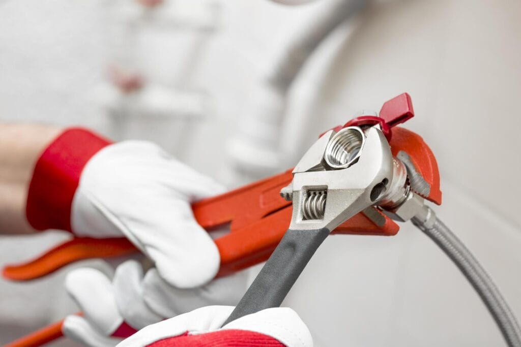 Plumber holding pipe wrenches for an emergency repair in Riverview