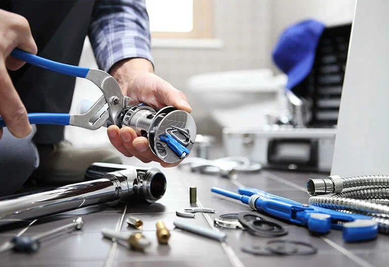 Technician repairing a plumbing fixture with professional tools in Riverview