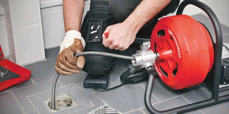 Plumber using a drain-cleaning machine in Riverview