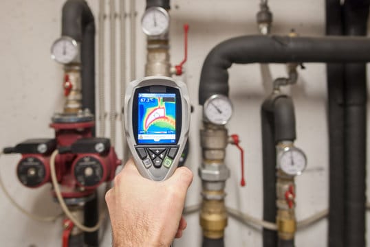 Plumber using a thermal imaging camera to inspect pipes in Riverview