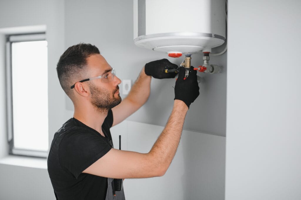 Technician performing water heater maintenance in Riverview