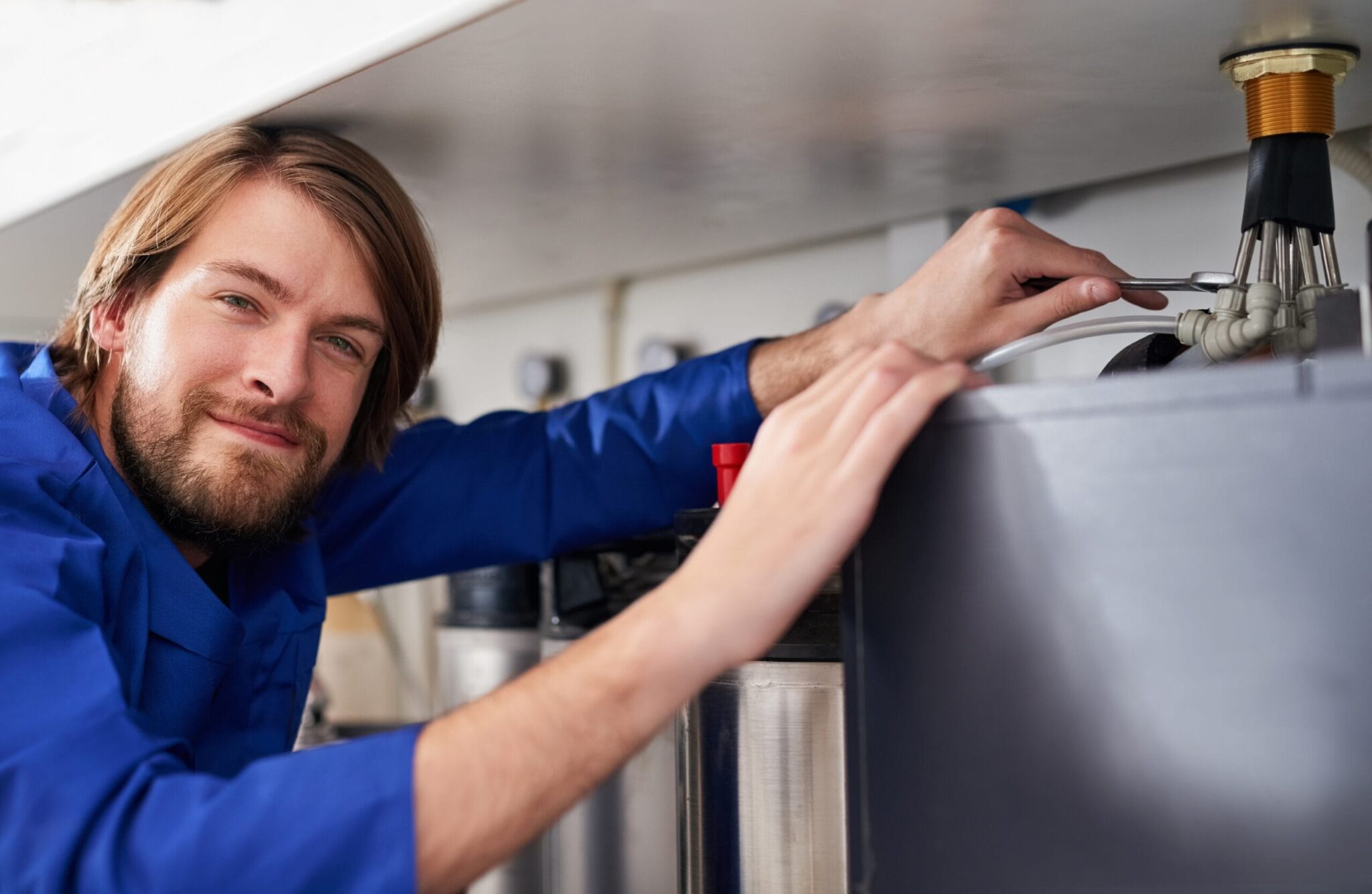 Technician servicing a residential water heater tank in Riverview