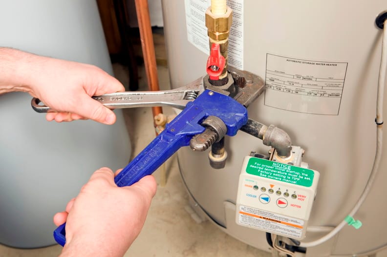 Plumber repairing a water heater valve in Riverview